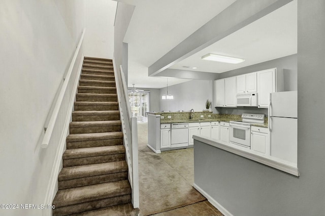 kitchen with kitchen peninsula, ceiling fan, white cabinets, and white appliances