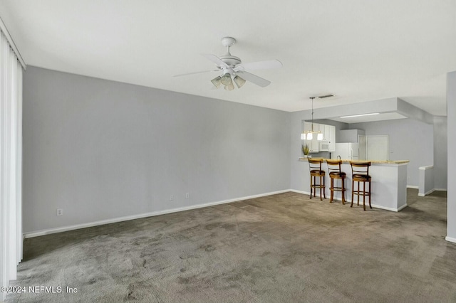 interior space with dark colored carpet and ceiling fan