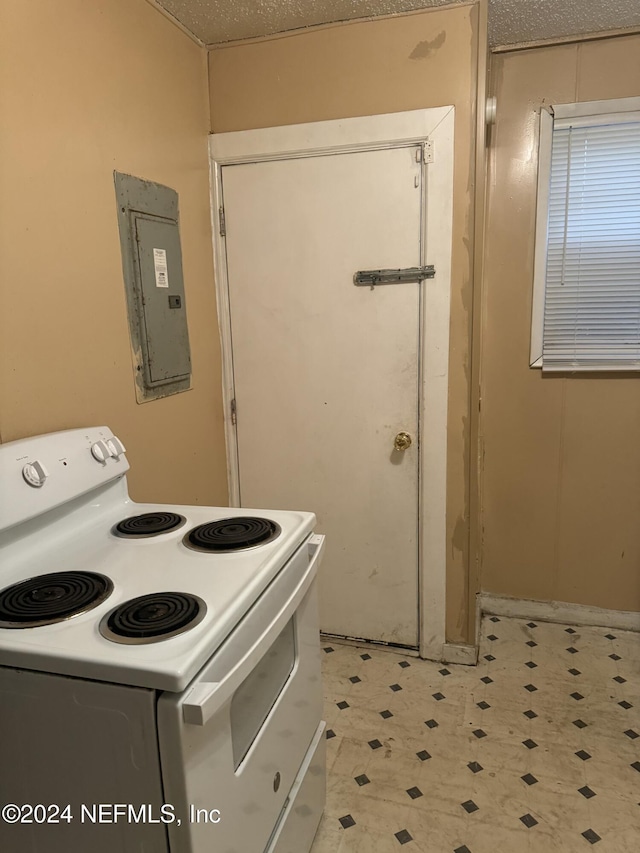 kitchen featuring electric panel, white electric range oven, and a textured ceiling