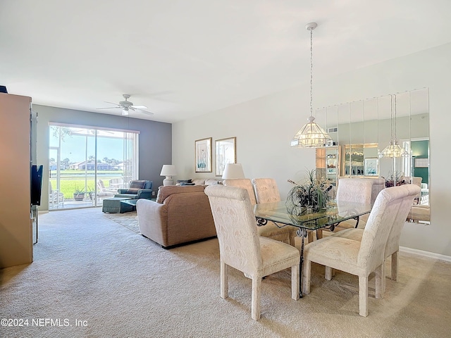 dining room featuring light colored carpet and ceiling fan with notable chandelier