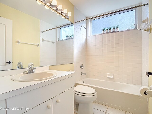 full bathroom featuring tile patterned flooring, vanity, tiled shower / bath combo, and toilet