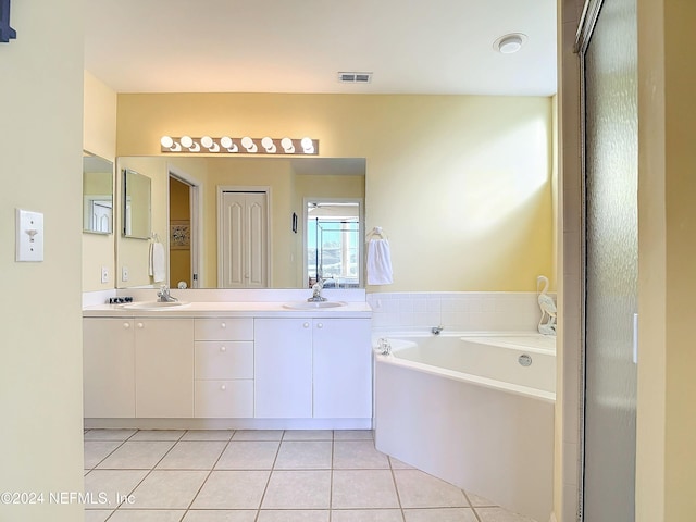 bathroom featuring tile patterned floors, a tub to relax in, and vanity