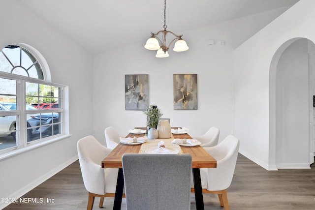 dining area featuring dark hardwood / wood-style flooring, lofted ceiling, and a chandelier