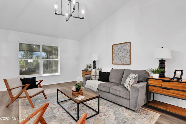 living room featuring wood-type flooring, high vaulted ceiling, and a chandelier