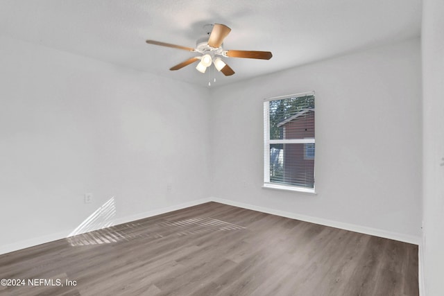 empty room featuring ceiling fan, wood-type flooring, and a textured ceiling