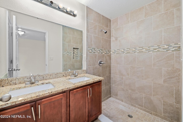 bathroom featuring vanity, a textured ceiling, and tiled shower