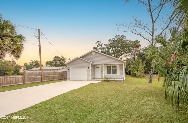 view of front of house with a garage and a yard