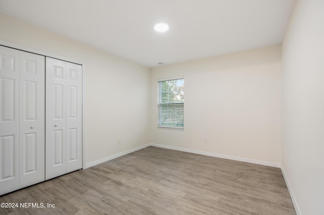 unfurnished bedroom featuring a closet and light wood-type flooring