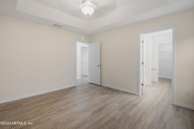 empty room with ceiling fan and light hardwood / wood-style floors