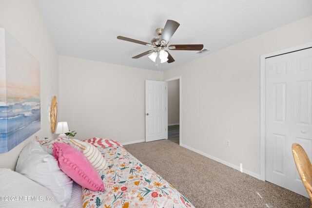 carpeted bedroom featuring ceiling fan and a closet