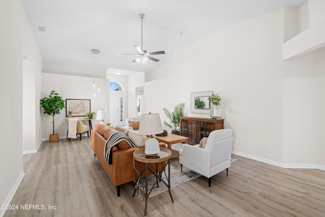 living room with ceiling fan, high vaulted ceiling, and light wood-type flooring