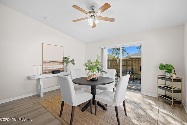 dining area featuring light hardwood / wood-style floors, vaulted ceiling, and ceiling fan