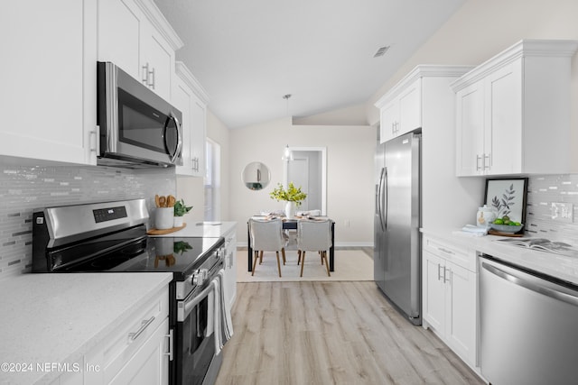 kitchen featuring white cabinets, stainless steel appliances, and lofted ceiling