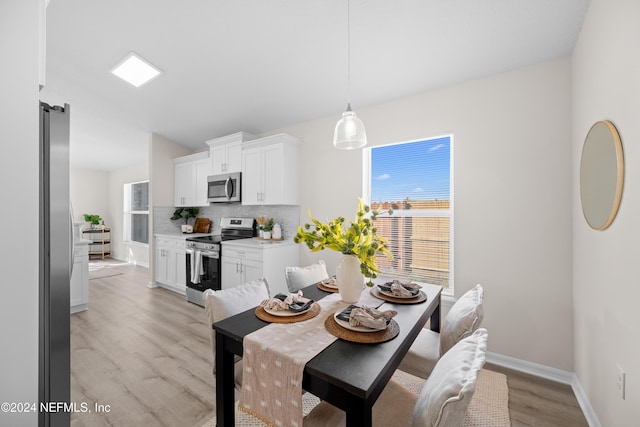 dining space with light hardwood / wood-style floors and plenty of natural light