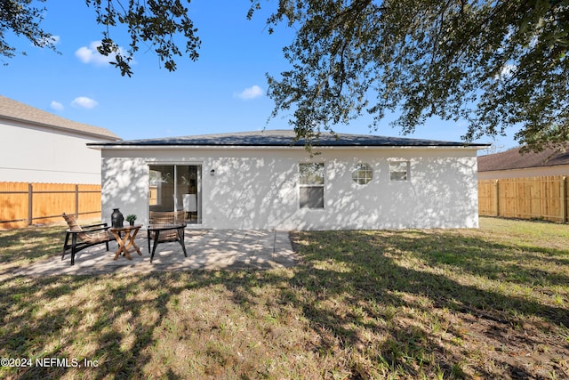 rear view of property with a patio area and a yard