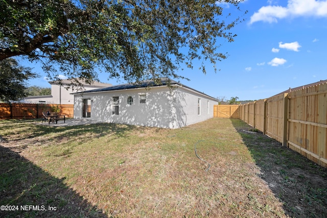 rear view of property featuring a lawn