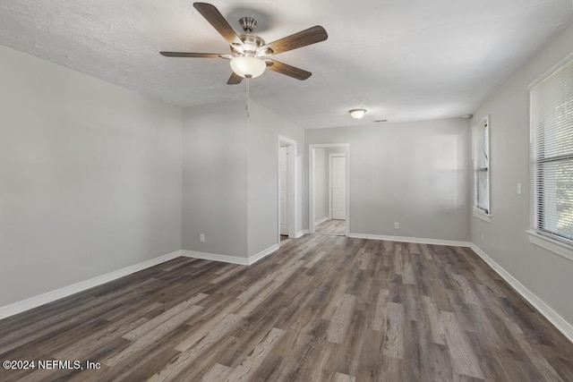 empty room featuring ceiling fan and dark wood-type flooring