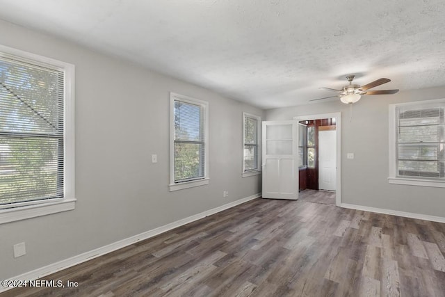 interior space with ceiling fan, wood-type flooring, and multiple windows