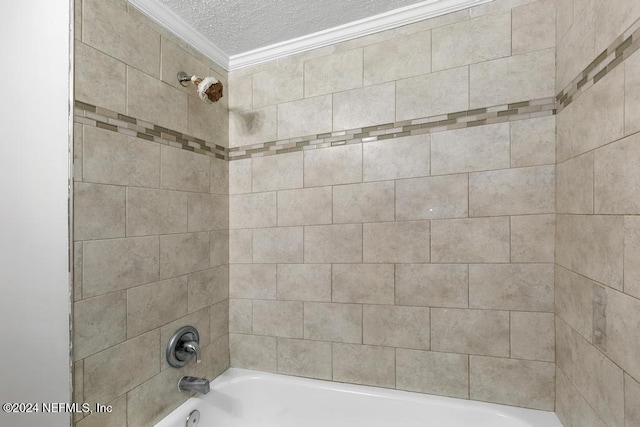 bathroom with a textured ceiling, tiled shower / bath combo, and ornamental molding