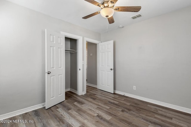 unfurnished bedroom with a closet, hardwood / wood-style flooring, and ceiling fan