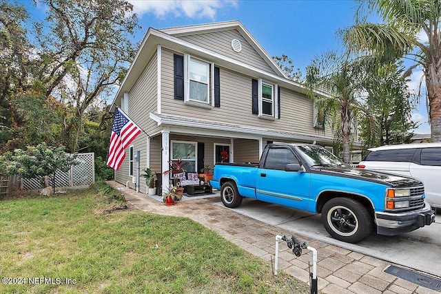 view of front facade featuring concrete driveway and a front yard