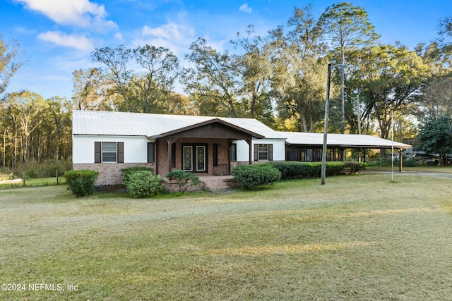 ranch-style house featuring a front yard and a carport