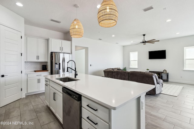 kitchen with white cabinets, a center island with sink, sink, and appliances with stainless steel finishes