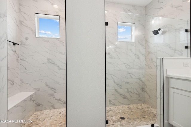 bathroom featuring a tile shower and vanity