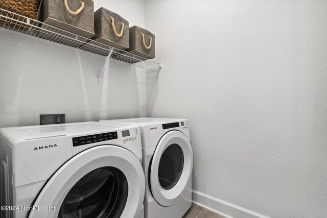 washroom with washer and clothes dryer and tile patterned flooring