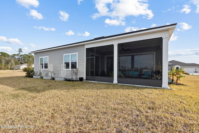 rear view of house with a lawn and a sunroom