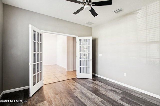 spare room featuring french doors, ceiling fan, and wood-type flooring