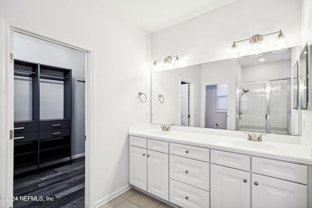 bathroom with tile patterned floors, a shower with door, and vanity