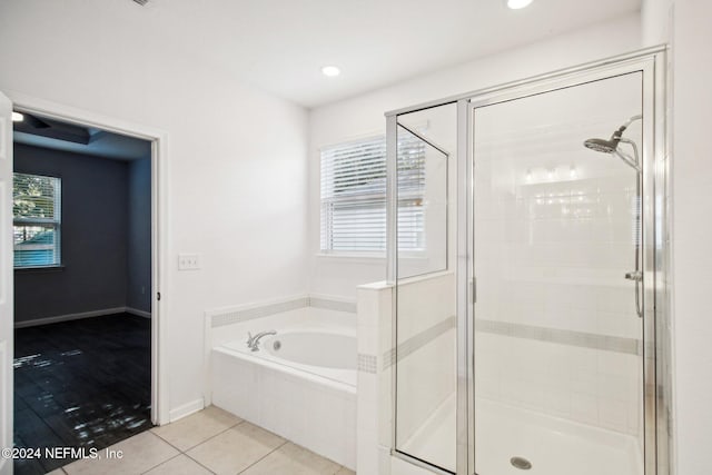 bathroom with tile patterned floors and shower with separate bathtub