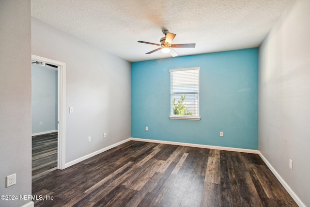 empty room featuring a textured ceiling, ceiling fan, and dark wood-type flooring