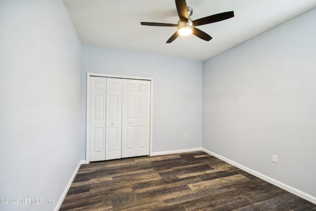 unfurnished bedroom with ceiling fan, dark hardwood / wood-style floors, and a closet