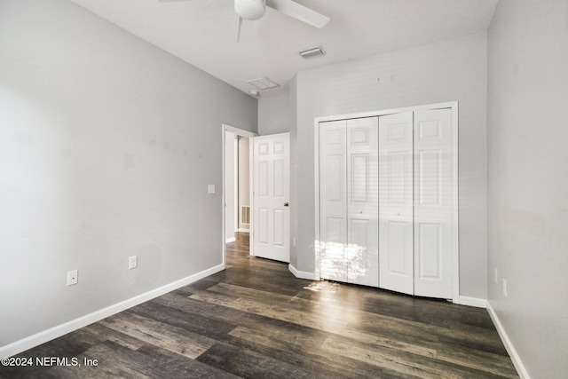 unfurnished bedroom with ceiling fan, a closet, and dark wood-type flooring