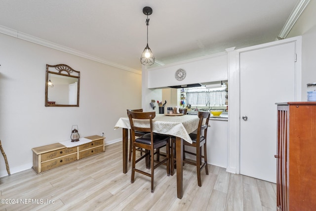 dining space featuring crown molding and light wood-type flooring