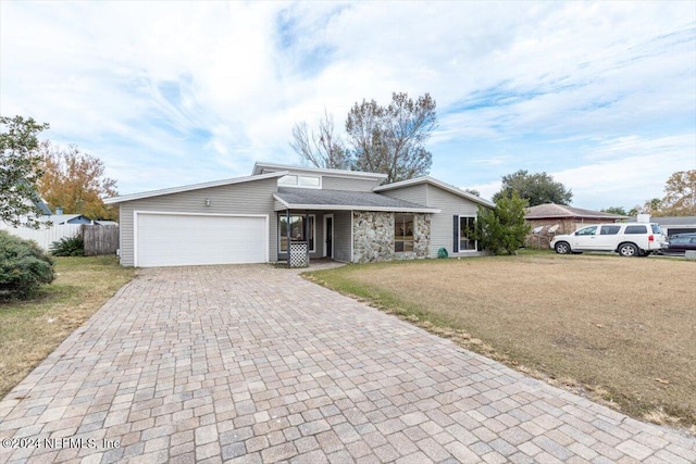 ranch-style home with a front lawn and a garage