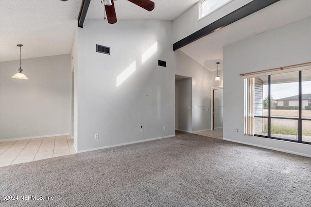 carpeted empty room with beam ceiling, a textured ceiling, high vaulted ceiling, and ceiling fan