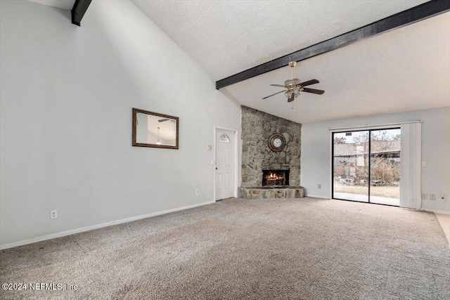 unfurnished living room with beam ceiling, ceiling fan, carpet floors, a textured ceiling, and a fireplace