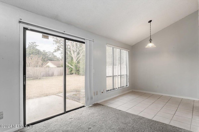 interior space with a textured ceiling, light tile patterned floors, and lofted ceiling