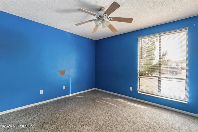 unfurnished room with ceiling fan, carpet, and a textured ceiling