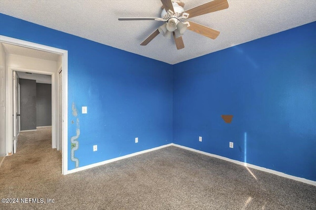 carpeted empty room with ceiling fan and a textured ceiling