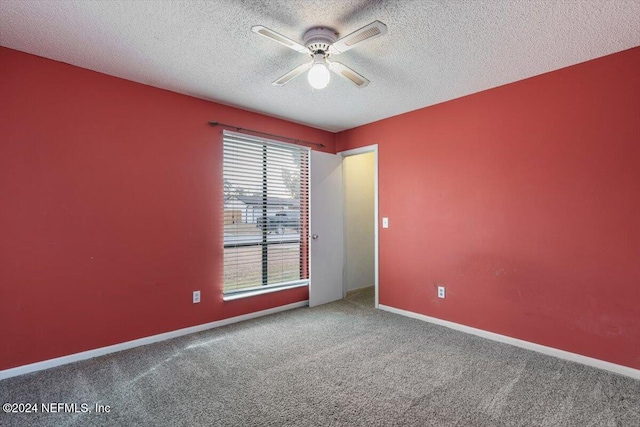 carpeted empty room with ceiling fan, a healthy amount of sunlight, and a textured ceiling