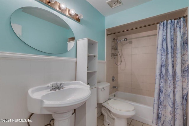 bathroom with tile patterned floors, shower / bathtub combination with curtain, and toilet