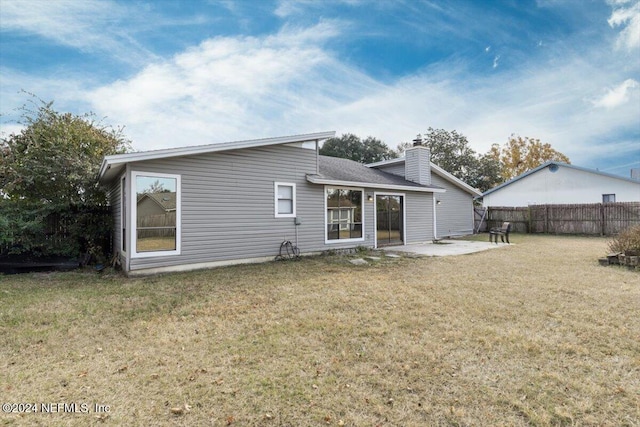 back of property with a patio and a lawn