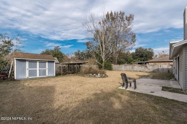 view of yard featuring a patio and a storage shed