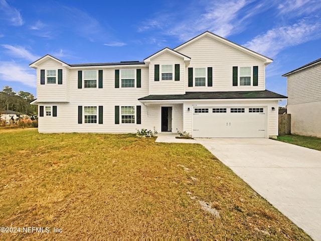 view of property featuring a garage and a front yard