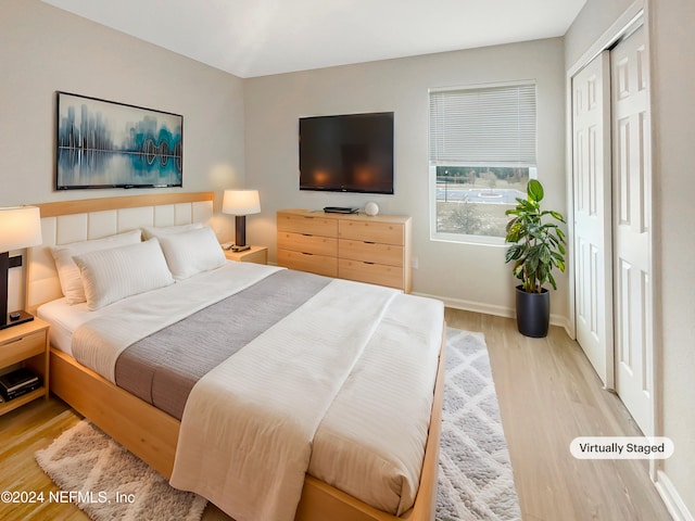 bedroom with light hardwood / wood-style floors and a closet