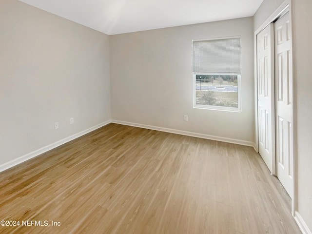 unfurnished bedroom featuring light hardwood / wood-style flooring and a closet